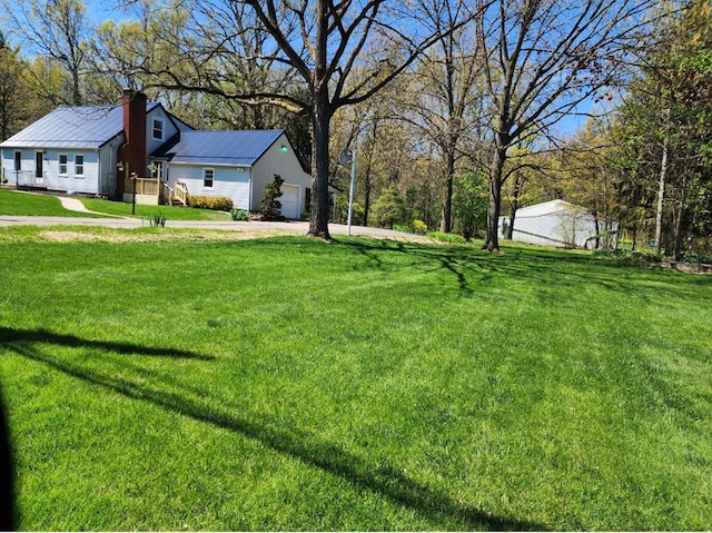 view of yard featuring driveway and a garage