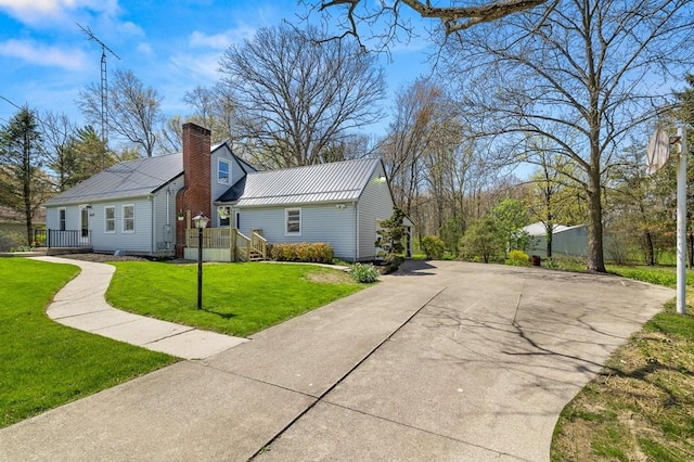 view of home's exterior featuring metal roof, a lawn, and a chimney