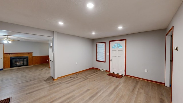 foyer entrance featuring a textured ceiling, light hardwood / wood-style floors, and ceiling fan