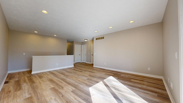 empty room with baseboards, visible vents, recessed lighting, and light wood-type flooring