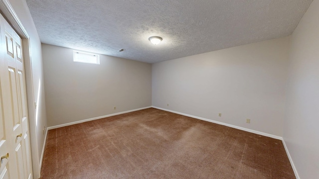 basement with baseboards, a textured ceiling, and carpet