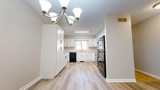 kitchen featuring light countertops, visible vents, a chandelier, tasteful backsplash, and black appliances