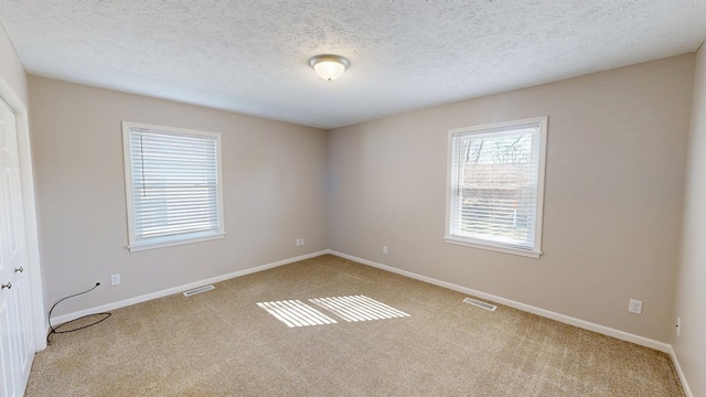 carpeted empty room with baseboards and visible vents