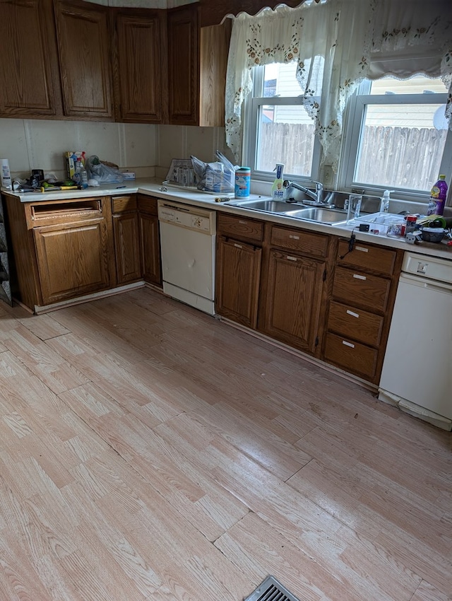 kitchen featuring dishwasher, light hardwood / wood-style floors, and sink