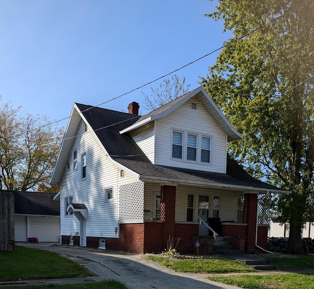 bungalow-style house featuring covered porch, a garage, and a front lawn