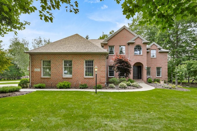 2313 Woodland Park Dr, Ontario, OH 44903 - view of front facade featuring a front lawn, brick siding, and a shingled roof