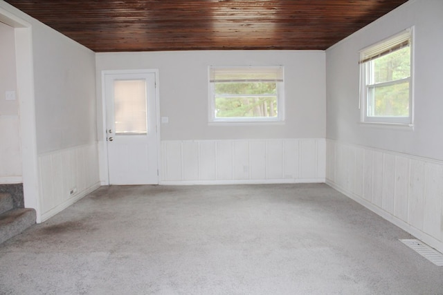 empty room featuring light carpet and wood ceiling