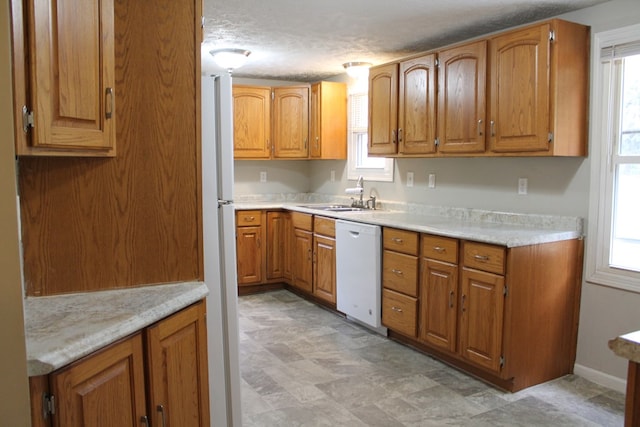 kitchen featuring white appliances, a healthy amount of sunlight, and sink