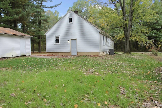 view of side of property with a yard and central AC unit