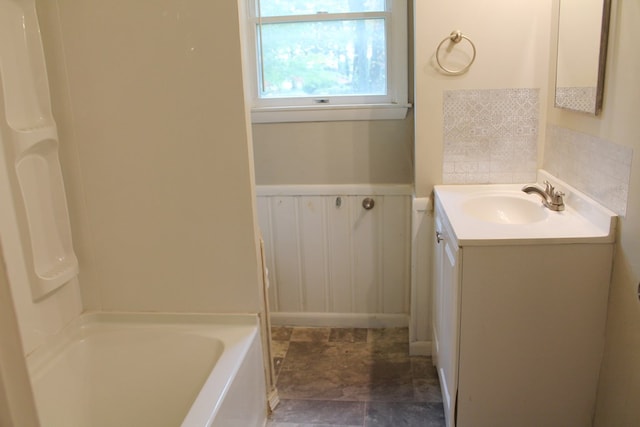 bathroom featuring vanity and a bath