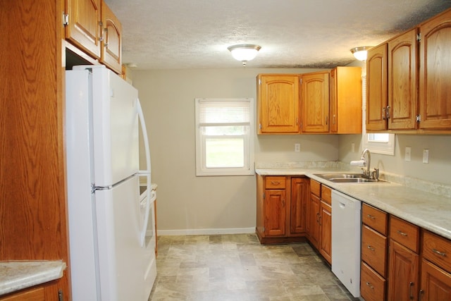 kitchen featuring a textured ceiling, sink, and white appliances