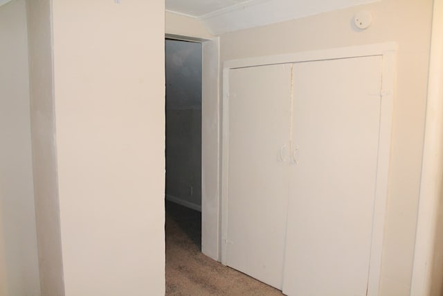 hallway with carpet flooring and vaulted ceiling