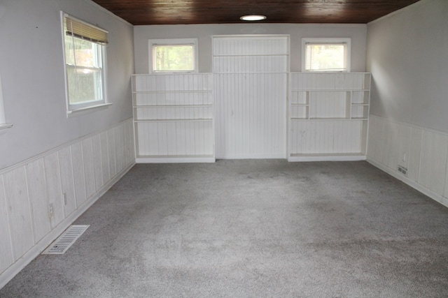 carpeted spare room with wood ceiling