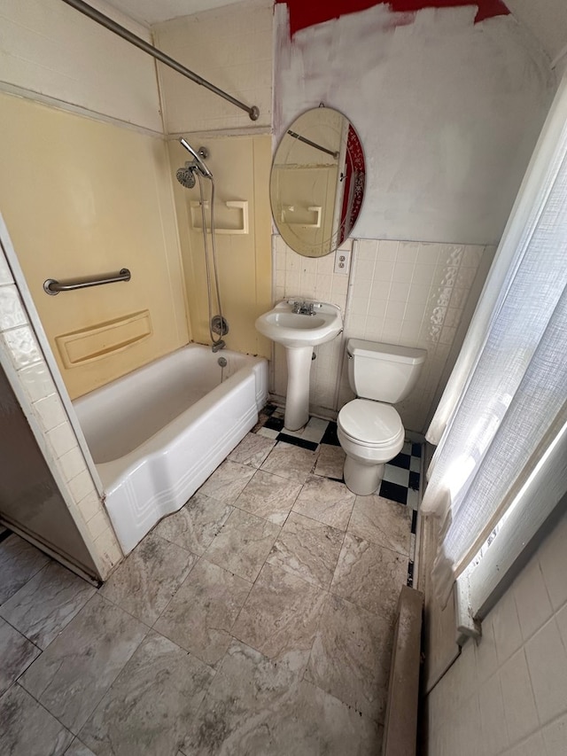 full bath featuring tile walls, toilet, shower / bathing tub combination, and a sink