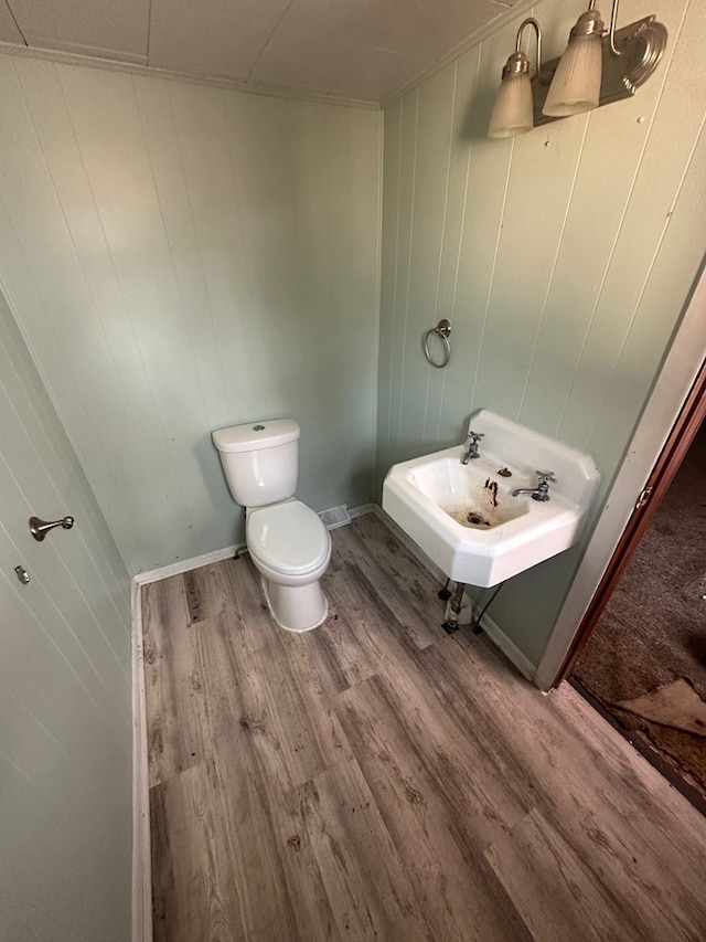 bathroom with a sink, toilet, and wood finished floors