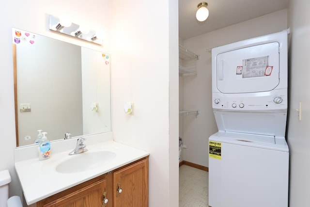 bathroom featuring tile patterned floors, vanity, and stacked washer / dryer