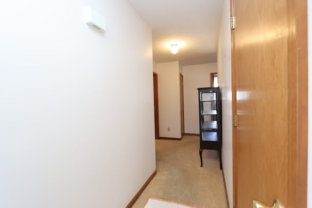 hallway with light carpet and baseboards