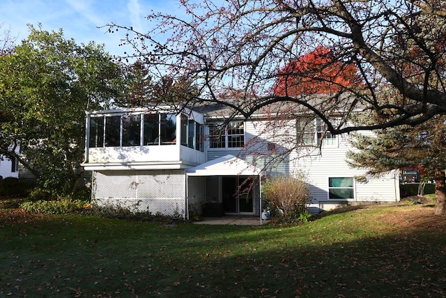 back of house with a yard and a sunroom