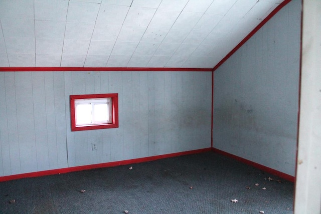 carpeted spare room with lofted ceiling