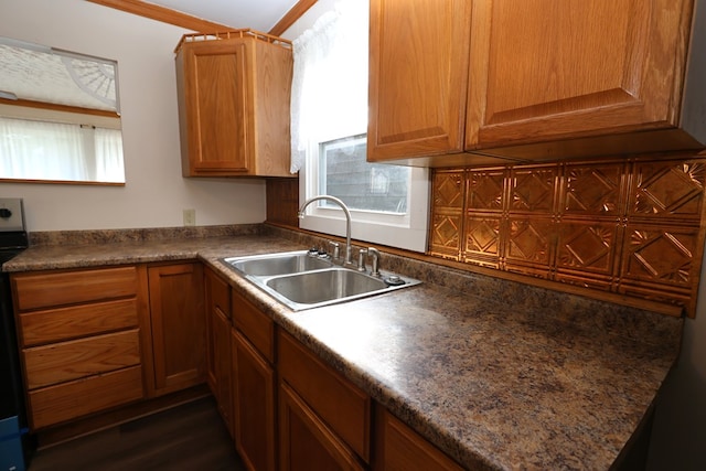 kitchen featuring stove, dark hardwood / wood-style flooring, crown molding, and sink