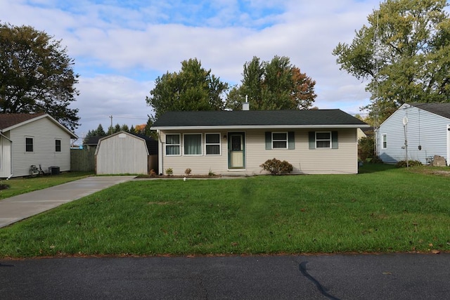 ranch-style home with central air condition unit, a front yard, and a storage shed