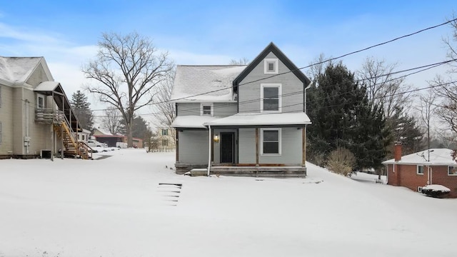 snow covered property with a porch