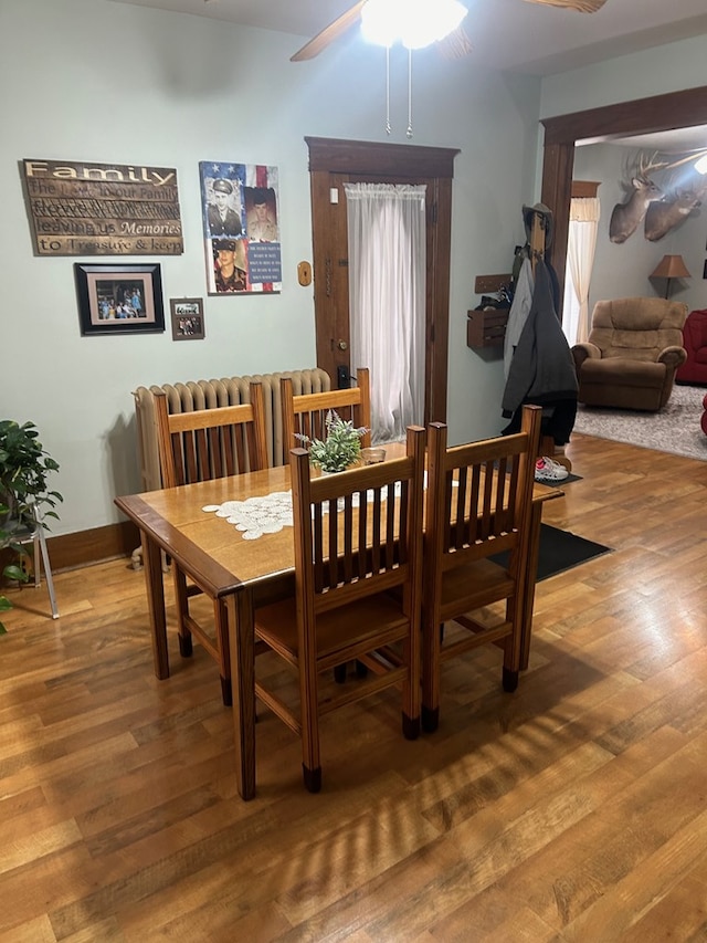 dining area with hardwood / wood-style floors and ceiling fan