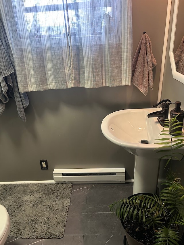 bathroom featuring tile patterned floors, toilet, and a baseboard heating unit