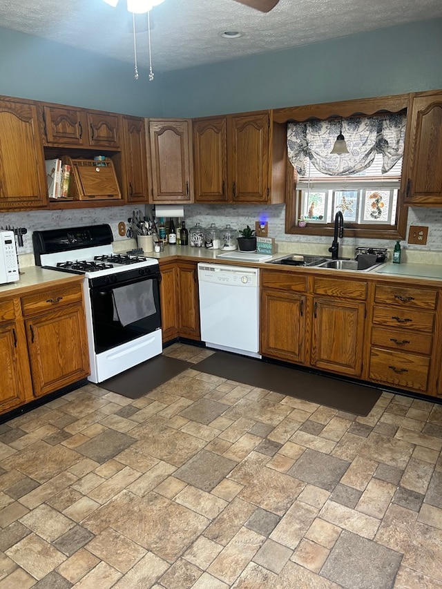 kitchen with a textured ceiling, ceiling fan, sink, and white appliances