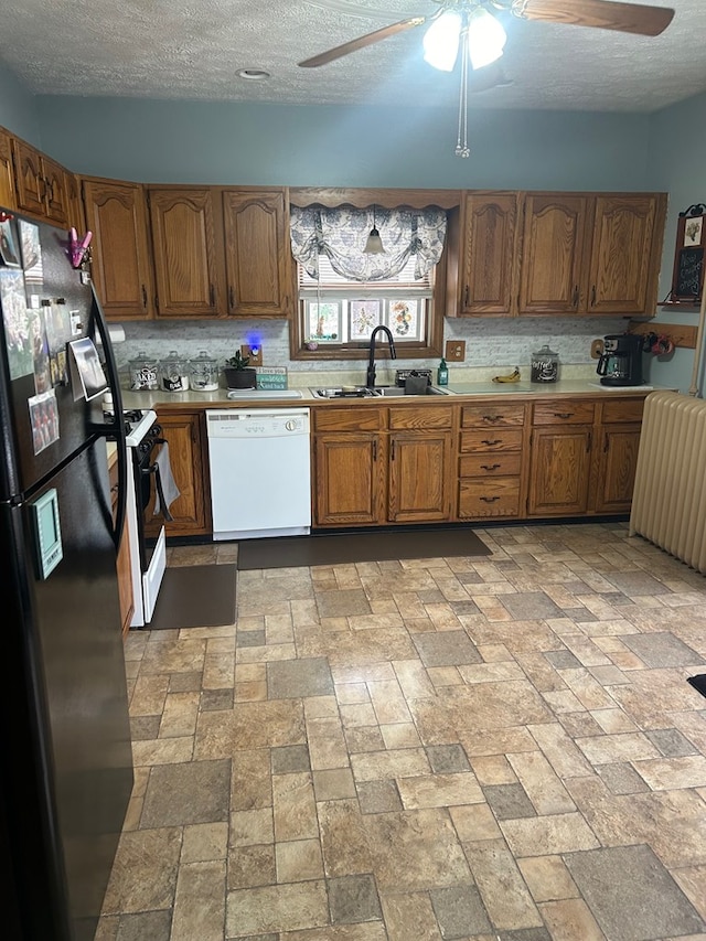 kitchen featuring a textured ceiling, white appliances, and sink