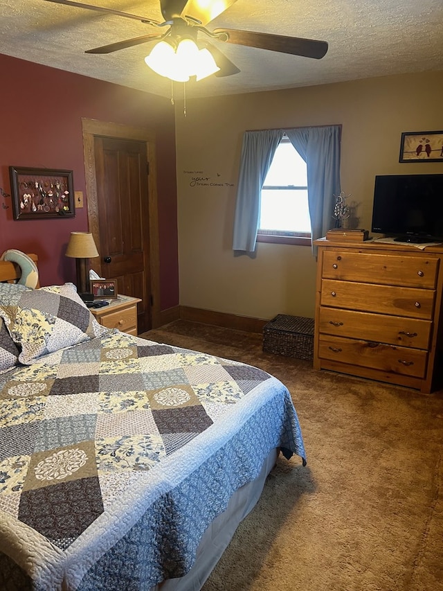 carpeted bedroom with ceiling fan and a textured ceiling