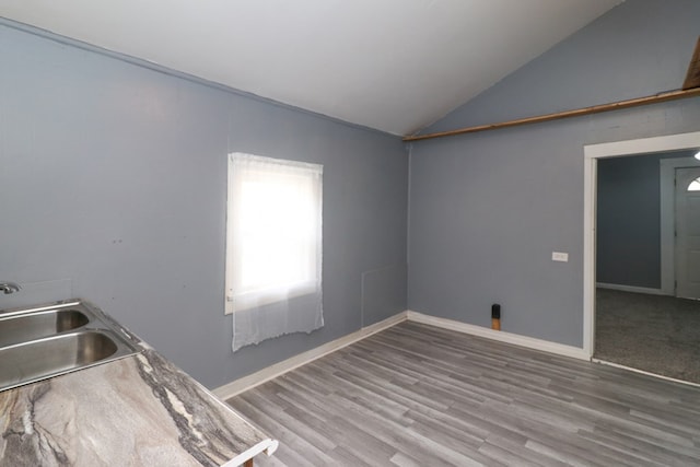 interior space featuring hardwood / wood-style flooring, sink, and vaulted ceiling