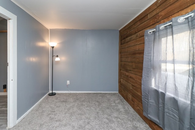 carpeted spare room with wooden walls