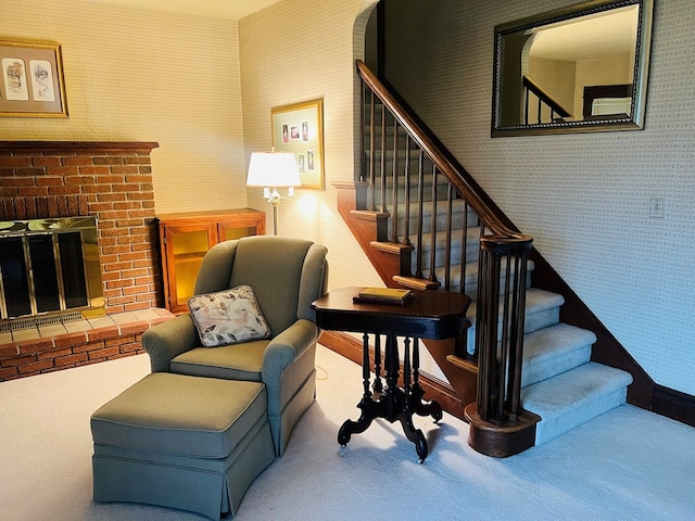 stairway with carpet floors and a brick fireplace