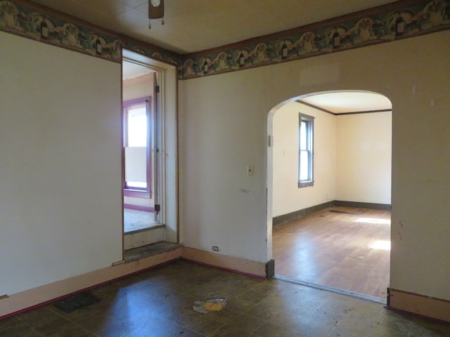 875 E Walnut St, Galion, OH 44833 - empty room with arched walkways, a ceiling fan, and baseboards
