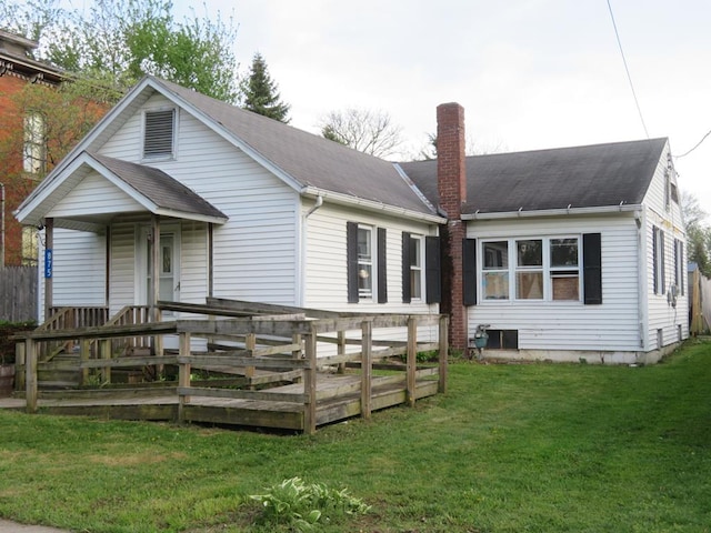 875 E Walnut St, Galion, OH 44833 - rear view of house with a chimney, a lawn, and roof with shingles