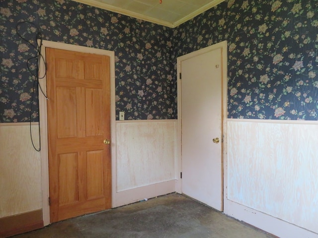 875 E Walnut St, Galion, OH 44833 - spare room featuring a wainscoted wall, unfinished concrete flooring, wallpapered walls, and crown molding