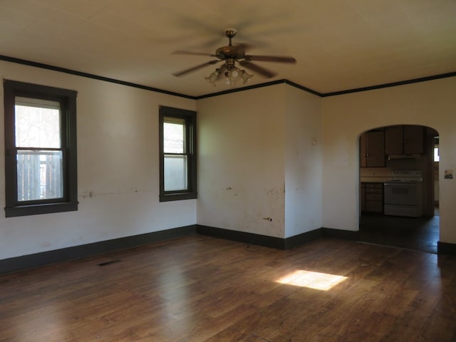 875 E Walnut St, Galion, OH 44833 - spare room with arched walkways, crown molding, ceiling fan, dark wood-style floors, and baseboards