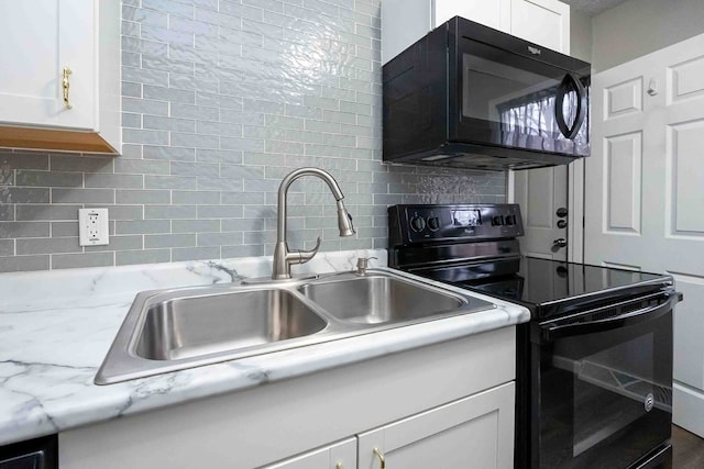 kitchen featuring backsplash, light stone counters, sink, black appliances, and white cabinets