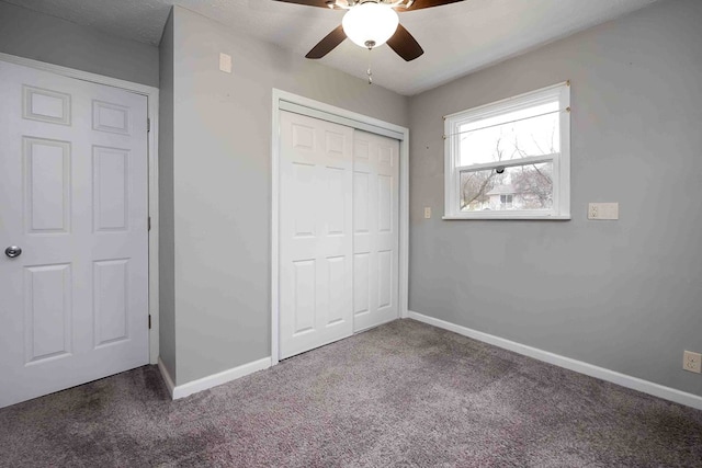 unfurnished bedroom featuring dark carpet, a closet, and ceiling fan