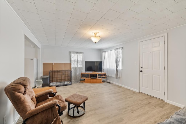 living area featuring light wood-type flooring and baseboards