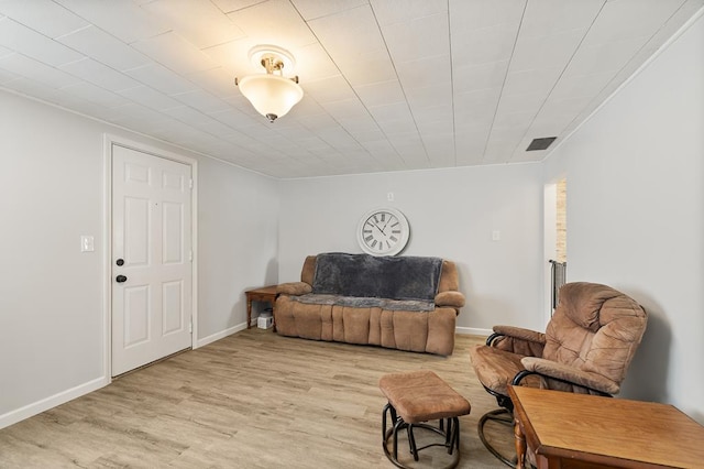 living area with light wood finished floors, baseboards, and visible vents