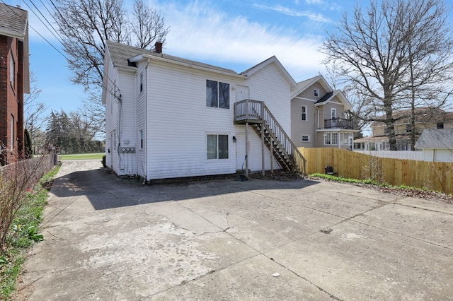 242 Davis Rd, Mansfield, OH 44907 - back of property with fence, driveway, a chimney, and stairway