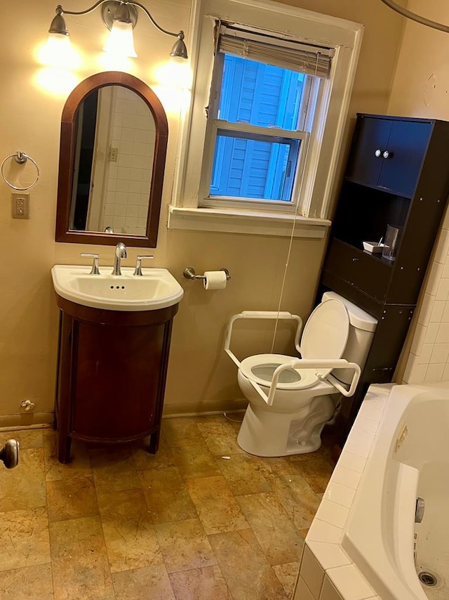242 Davis Rd, Mansfield, OH 44907 - bathroom with stone tile floors, vanity, a bathtub, baseboards, and toilet
