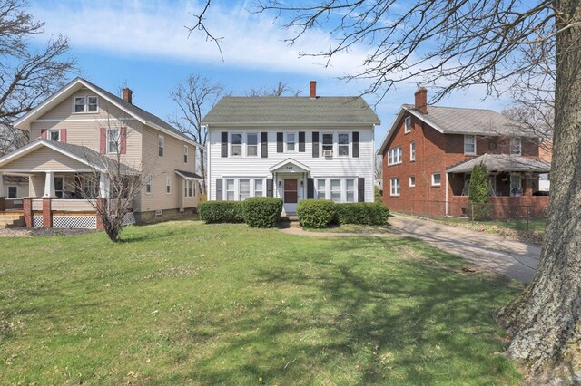 242 Davis Rd, Mansfield, OH 44907 - colonial house with a front lawn, covered porch, and a chimney