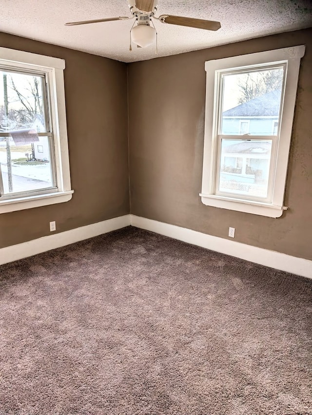 spare room featuring ceiling fan, plenty of natural light, carpet floors, and a textured ceiling