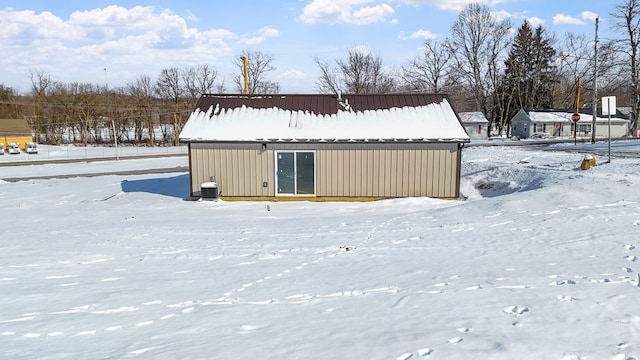 snow covered back of property with cooling unit