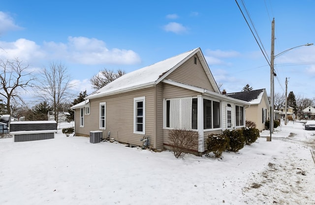 view of snowy exterior featuring central AC unit