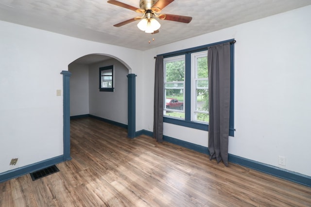 460 W Dickson, Mansfield, OH 44903 - empty room with arched walkways, ceiling fan, plenty of natural light, and wood finished floors
