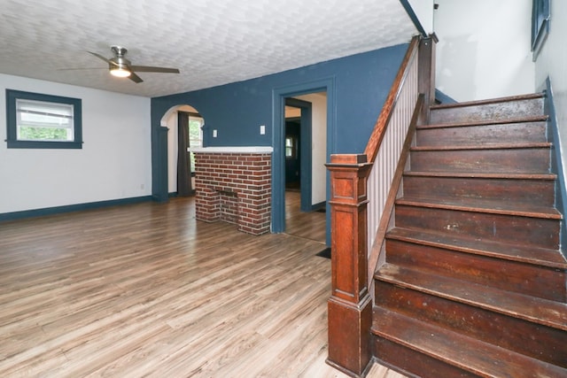460 W Dickson, Mansfield, OH 44903 - stairway with a ceiling fan, a fireplace, wood finished floors, arched walkways, and a textured ceiling